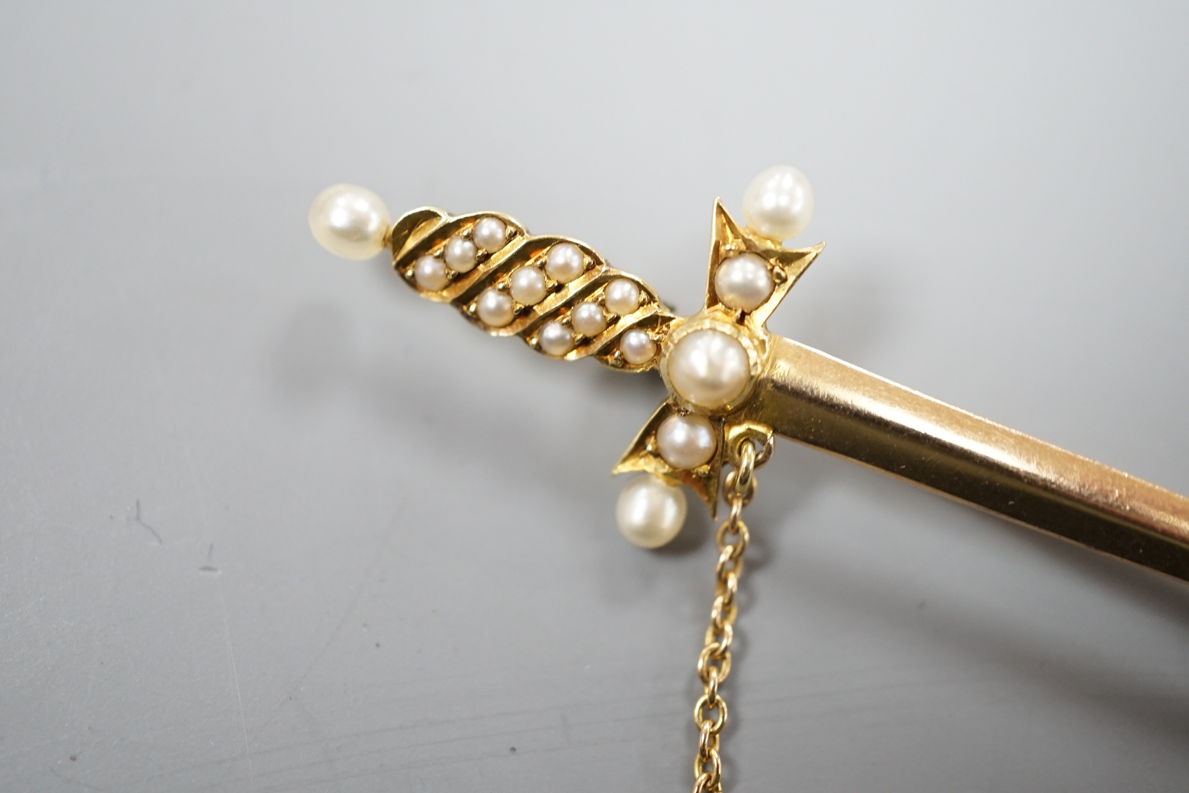 An Edwardian yellow metal and graduated seed pearl set dagger bar brooch, 60mm, gross weight 5 grams.